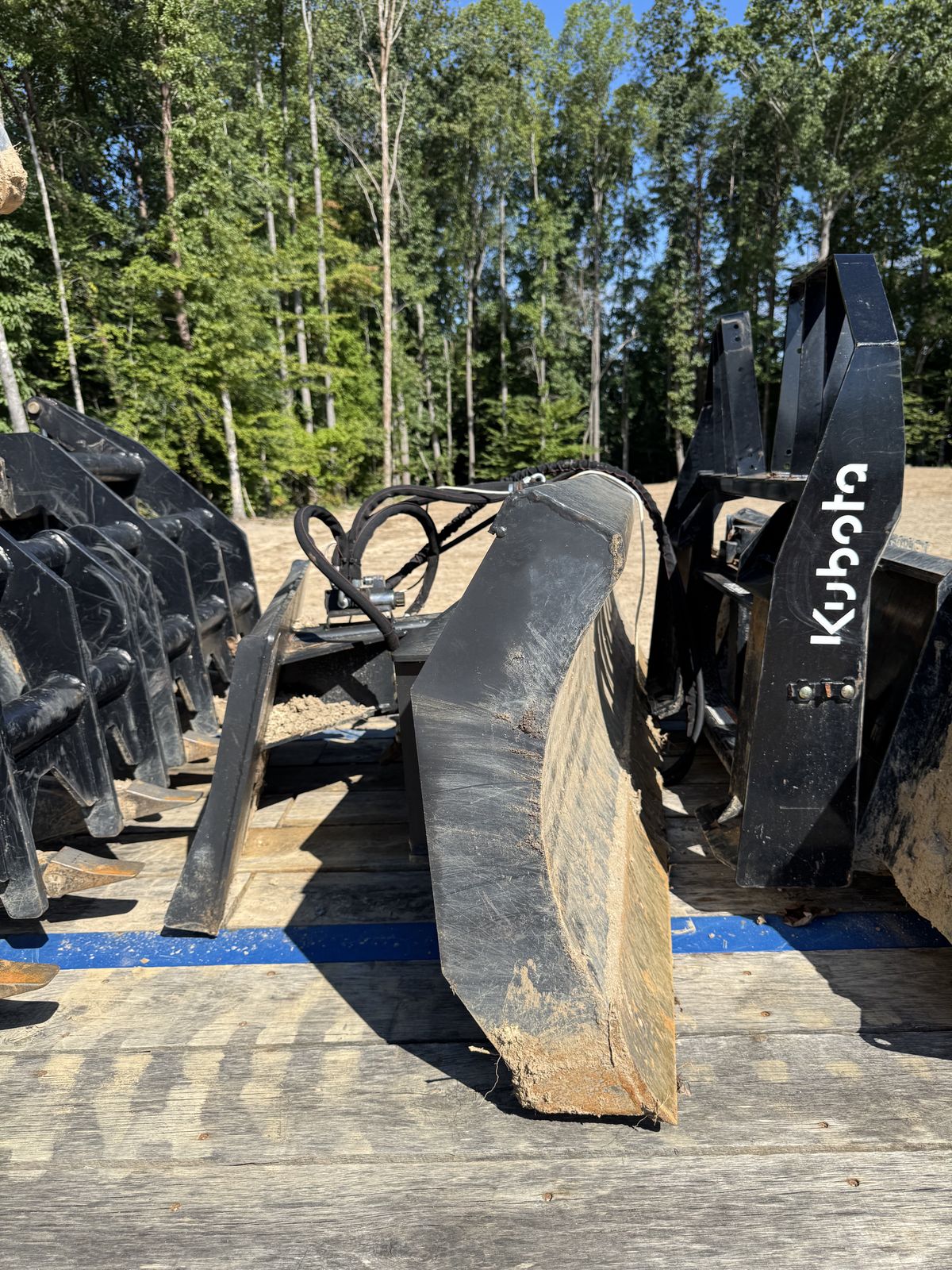 Grapple and bucket attachments loaded on the trailer
